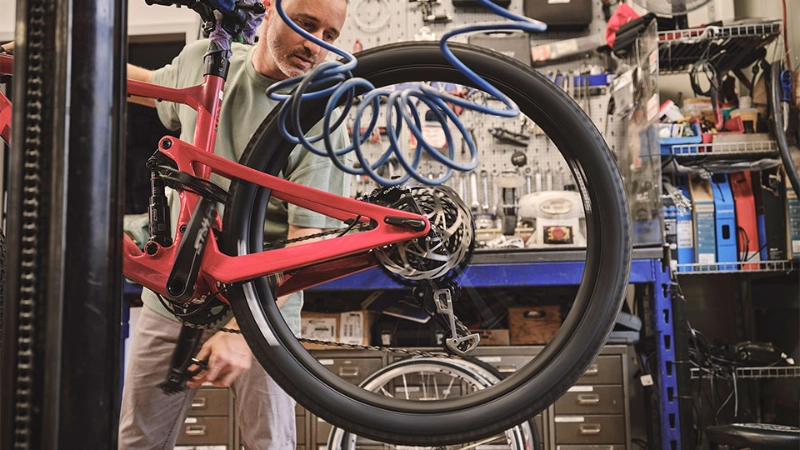 Ein Fachhändler überprüft den Reifendruck eines Fahrrads Ein Fachhändler überprüft den Reifendruck eines Fahrrads