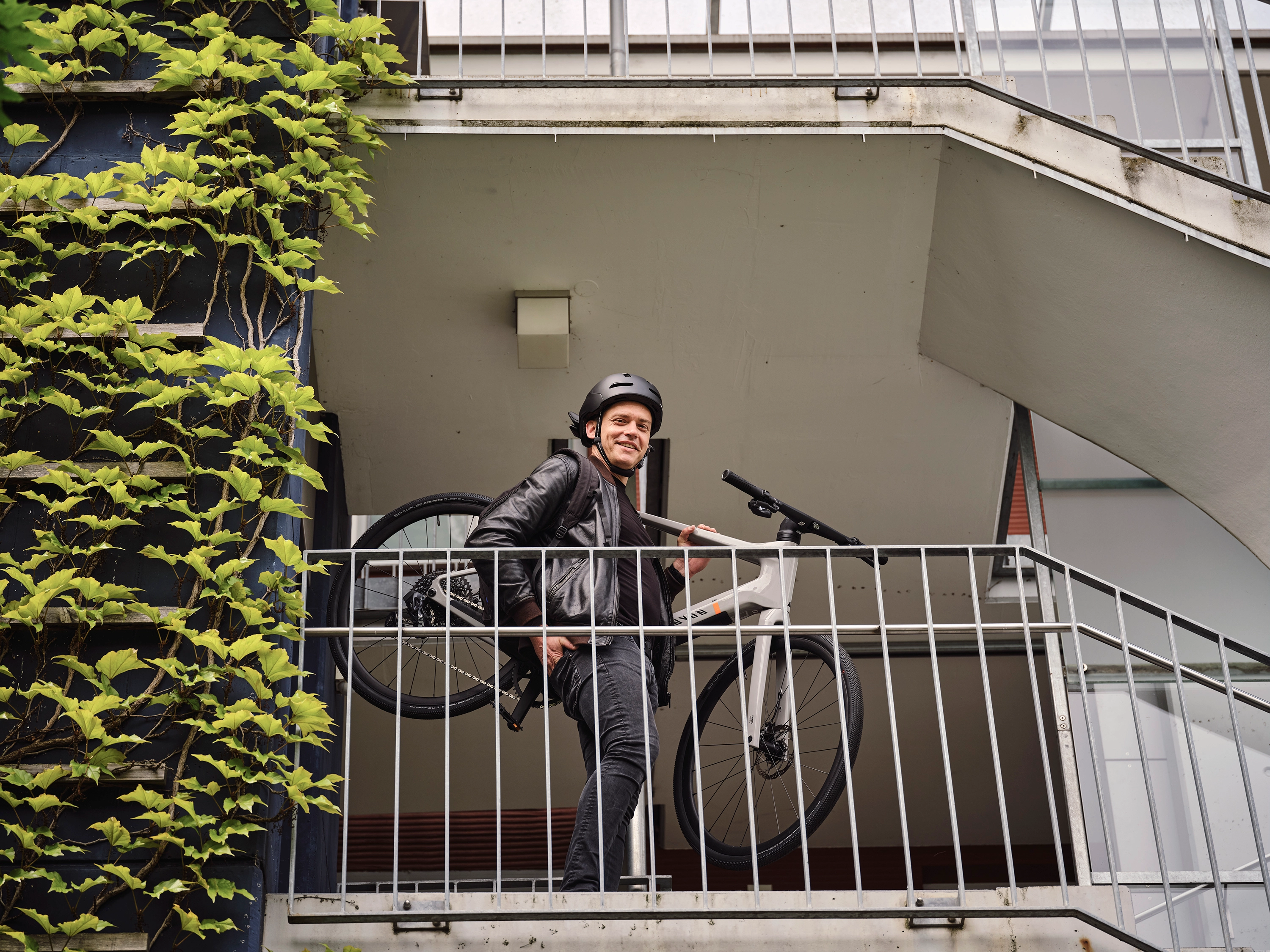JobRadler mit Fahrrad nimmt grinsend die Treppe JobRadler mit Fahrrad nimmt grinsend die Treppe