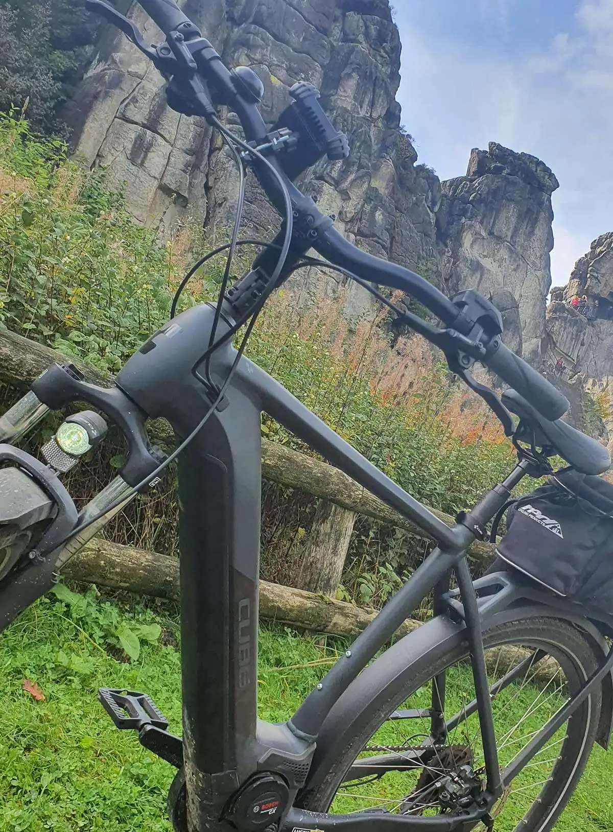 Ein schwarzes Fahrrad auf grünem Gras zwischen den Bergen